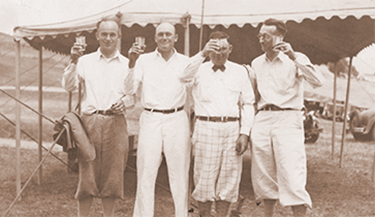 Old image of men drinking cocktails on golf course